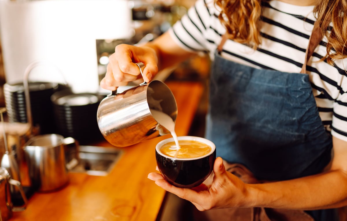 Barista preparing fresh coffee in a cozy cafe